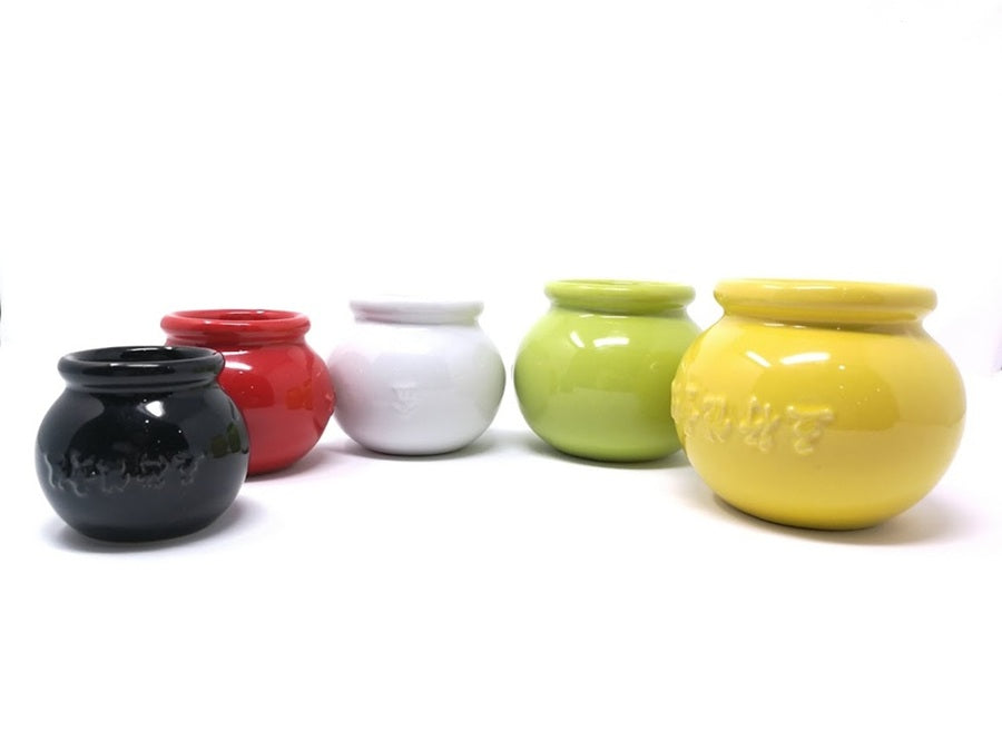 Set of five ceramic cups in black, red, white, green, and yellow on a white background