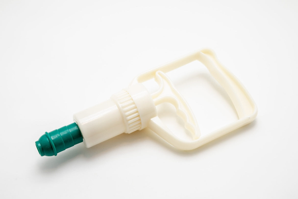 White plastic bottle with green nozzle on a white background