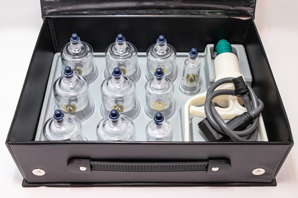 Cupping therapy set with glass cups and electronic device in a black carrying case.