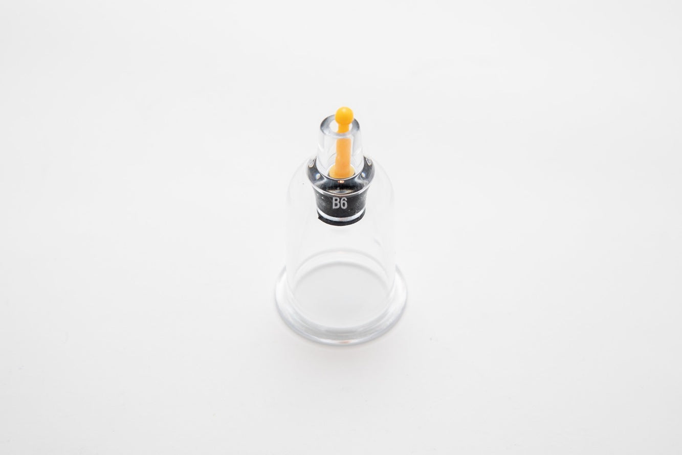 Small cylindrical container with a yellow cap on a white background