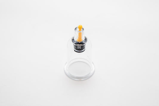 Small cylindrical container with a yellow cap on a white background