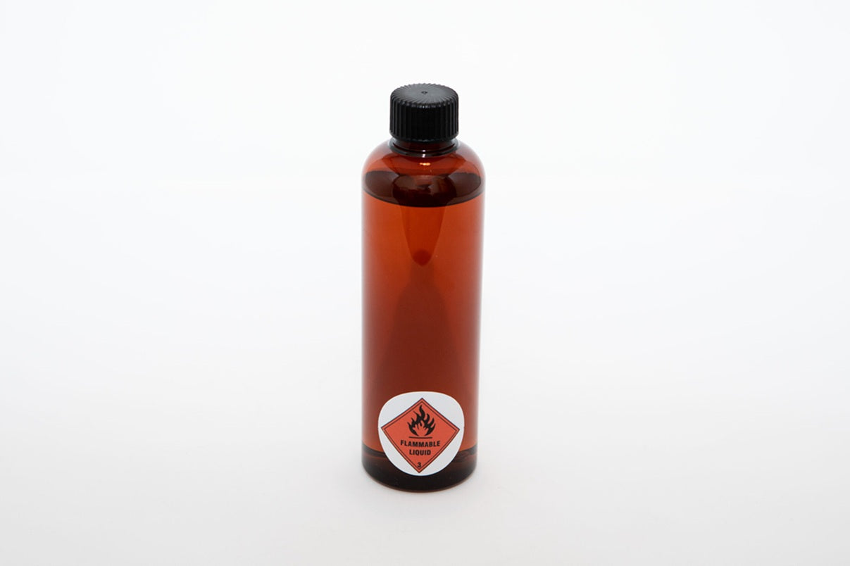 Bottle of flammable liquid with a warning label on a white background